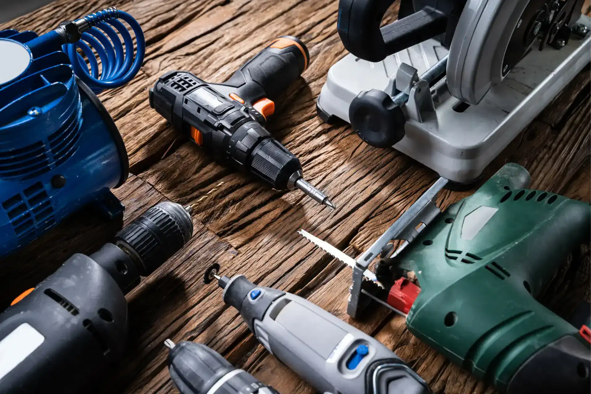 Various power tools laid out on a wooden table