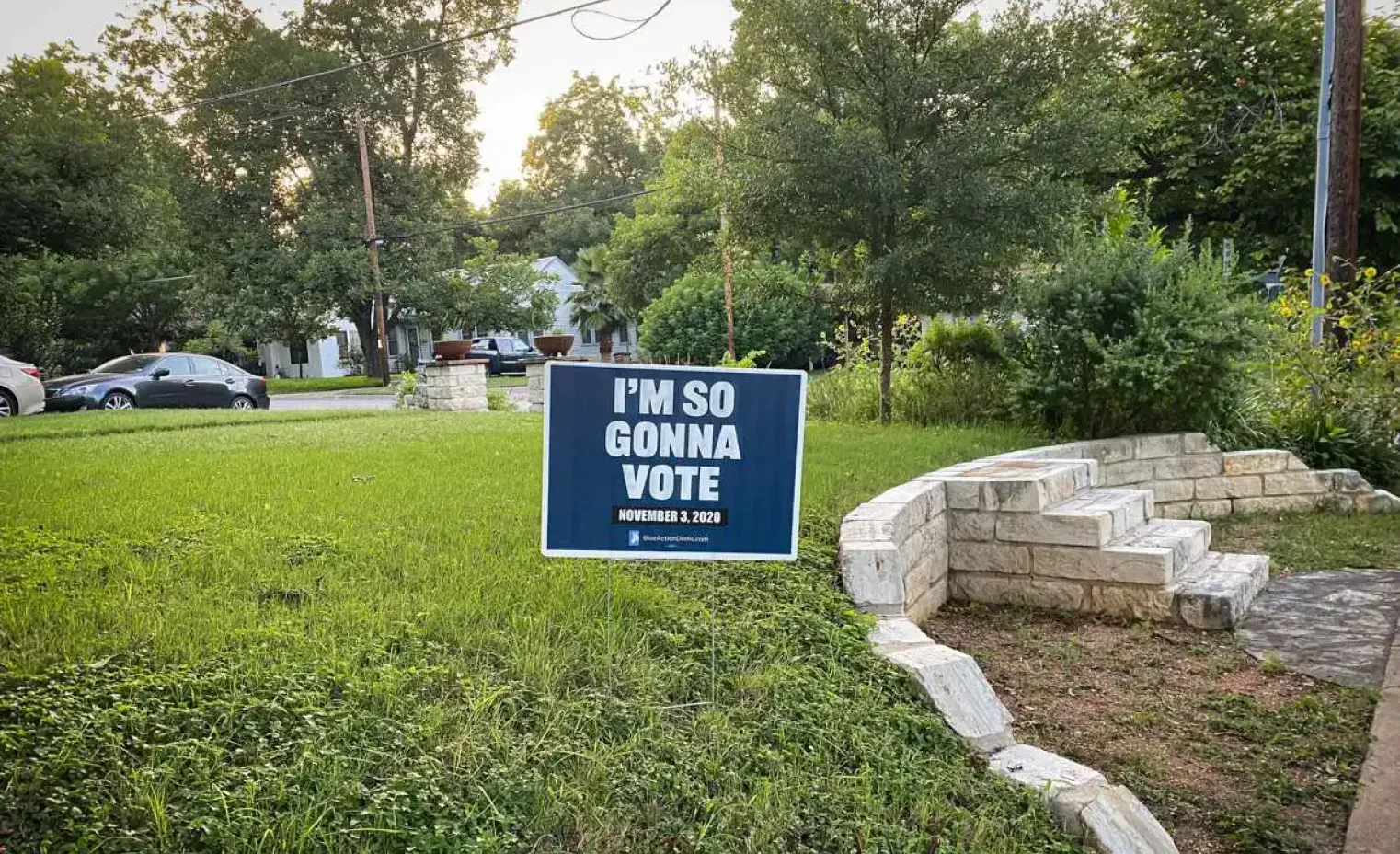 blue lawn sign planted in a suburban front yard.webp