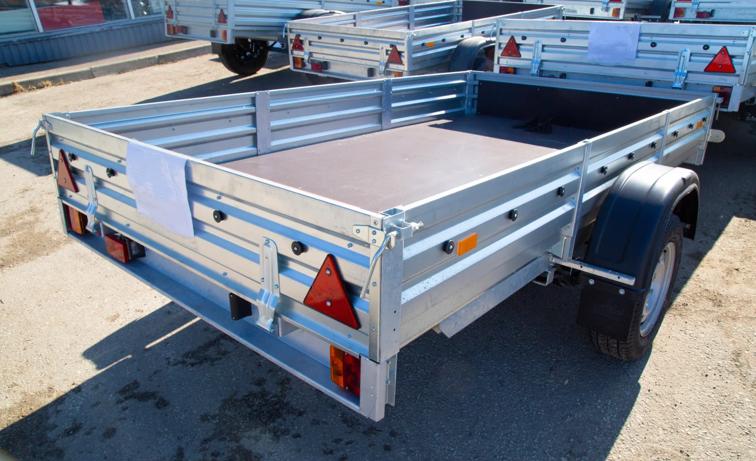 silver aluminium utility trailers ready to be hitched to a pickup truck.webp