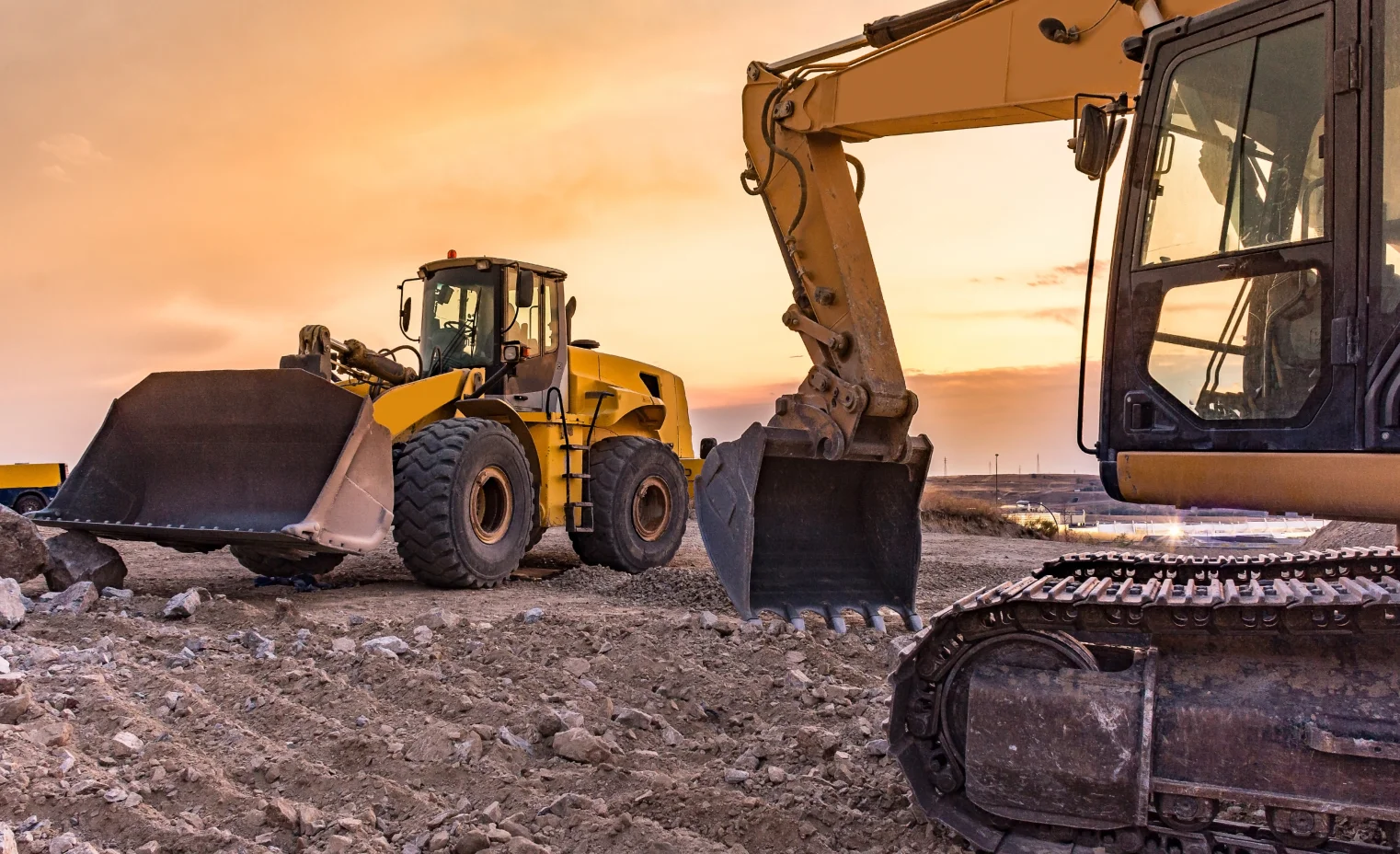 a medium sized yellow digger operating on a building site at sunset.webp