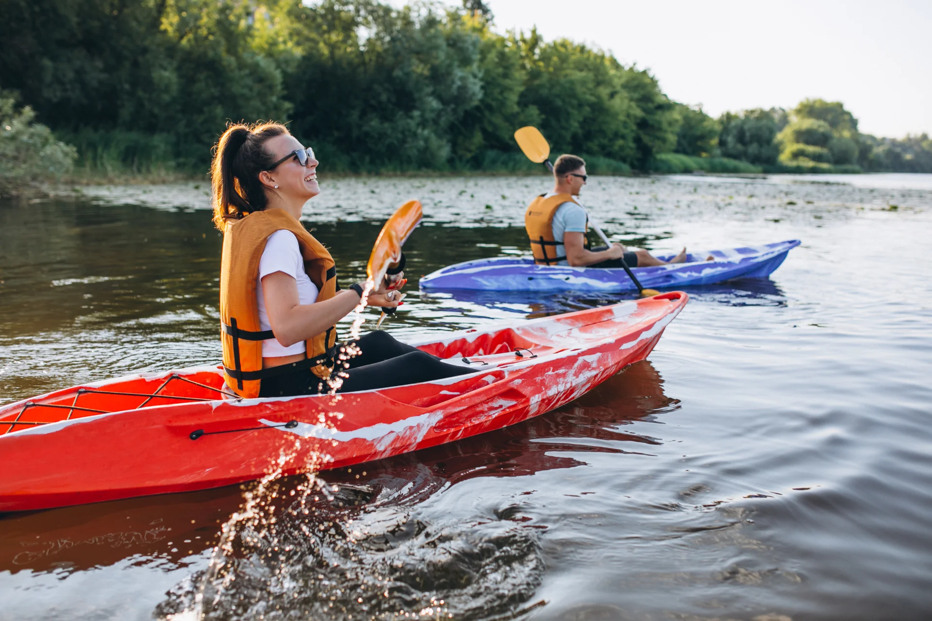 Couple kayaking down a calm river